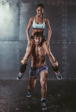 Atlet kaslı sporcu antreman yapıyor Crossfit fitness spor eğitim yaşam tarzı vücut geliştirme kavramı onun omuzlarında oturan kadın ile ağız kavgası.