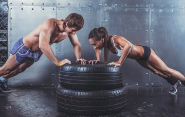Sporcular. Uygun sportif kadın ve gönderme yapan erkek ups üstünde lastik gücü güç eğitim kavramı crossfit egzersiz spor yaşam tarzı.