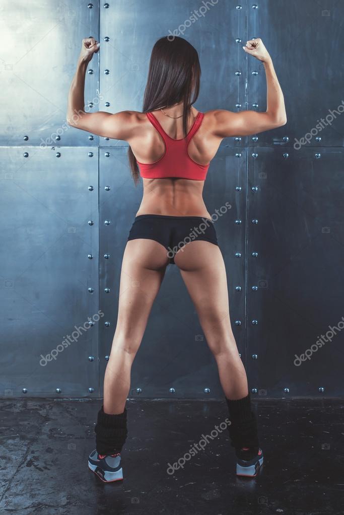 Muscular active athletic young woman showing muscles of the back