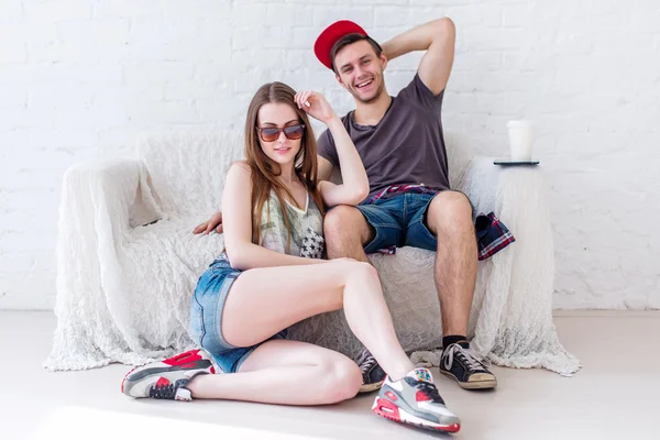 Friends smiling girl and boy at home in summer jeanswear street urban casual style talking, having fun. — Stockfoto