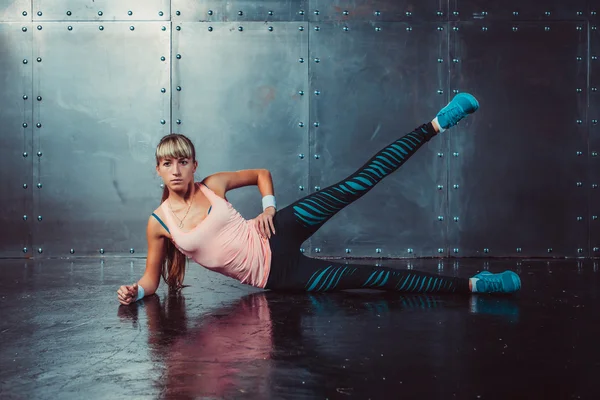 Athlete woman exercising warming up and stretching lying on her side the floor with  leg raised concept training fitness, sport, healthy lifestyle. — 图库照片