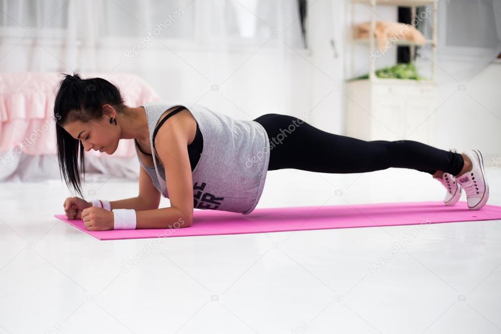 Slim fitness young woman Athlete girl doing plank exercise at home concept training workout crossfit gymnastics cross fit