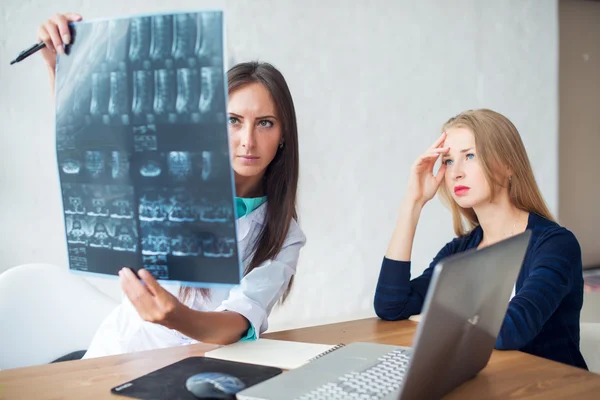 Žena lékař a pacient při pohledu na rentgen nebo Mri obrázek v nemocnici. — Stock fotografie