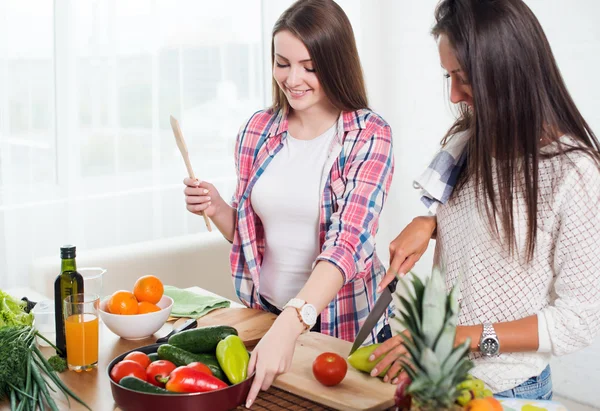 Vackra unga kvinnor förbereder middag i ett kök konceptet matlagning, kulinariska, hälsosam livsstil. — Stockfoto
