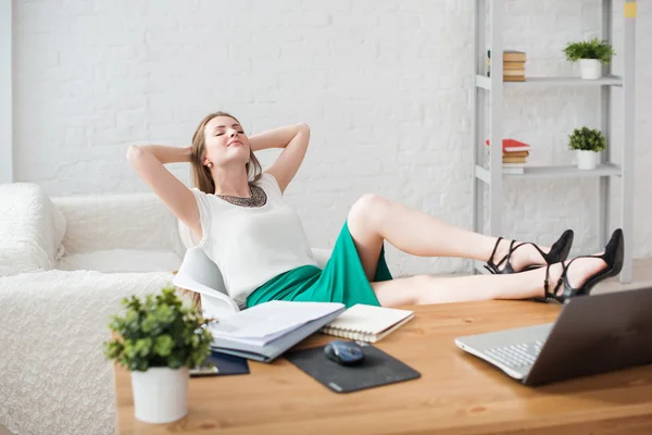 Mujer de negocios descansando piernas relajantes en la mesa manos detrás de la cabeza y sentado una silla en la oficina. — Foto de Stock