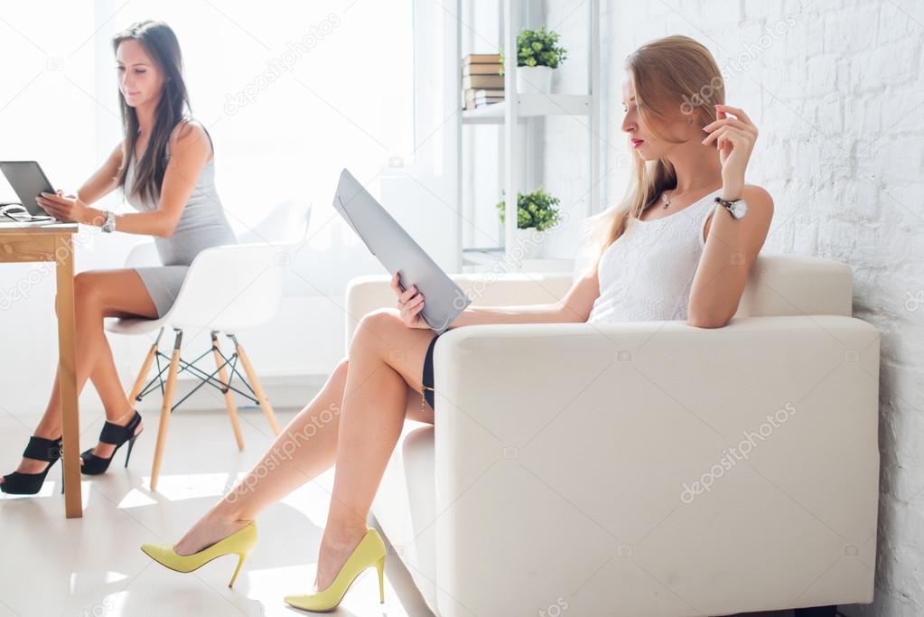 portrait of business woman with folder sitting at office on sofa