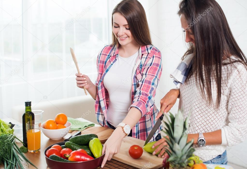 Gorgeous young Women preparing dinner in a kitchen concept cooking, culinary, healthy lifestyle.