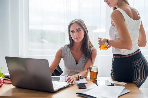 Young businesswoman sitting at desk — Stock Photo, Image