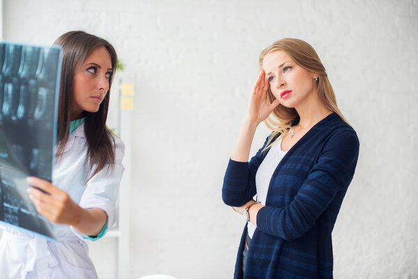 Doctor woman with white labcoat looking at x-ray