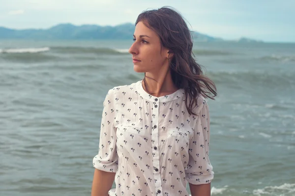 Young woman standing by sea — Stock Photo, Image