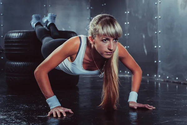 Sportig idrottsman kvinna göra push ups — Stockfoto