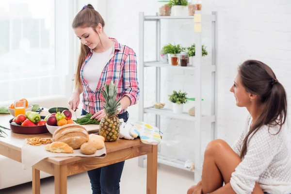 Kvinnan matlagning i köket och pratar med sin kompis — Stockfoto