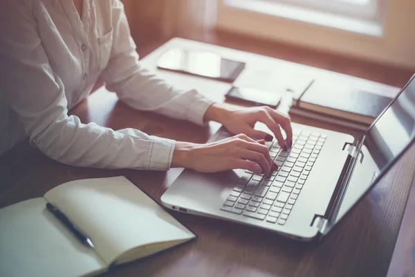 Geschäftsfrau tippt am Arbeitsplatz auf Laptop — Stockfoto