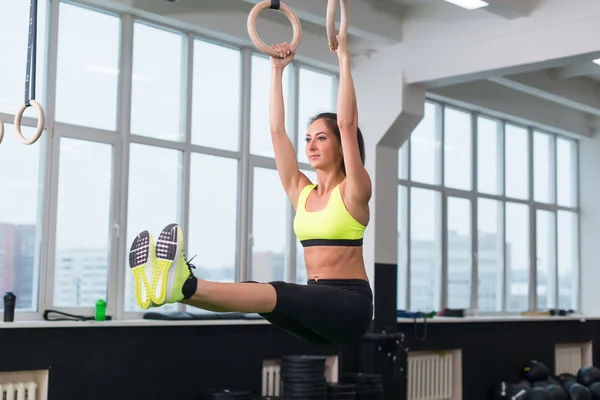 Женщина упражняется с гимнастическими кольцами — стоковое фото