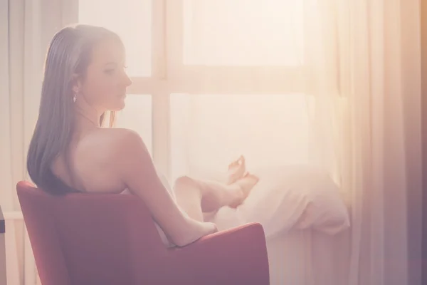 Mujer encantadora mirando a través de una ventana — Foto de Stock