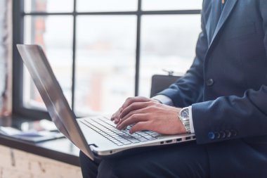 İşadamı laptopuyla çalışıyor.