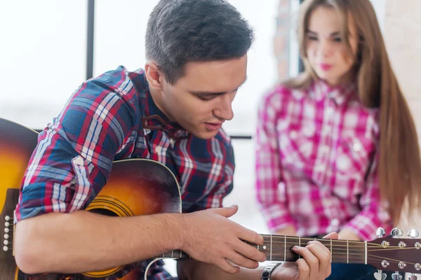 Молодой человек поет гитару для своей девушки — стоковое фото