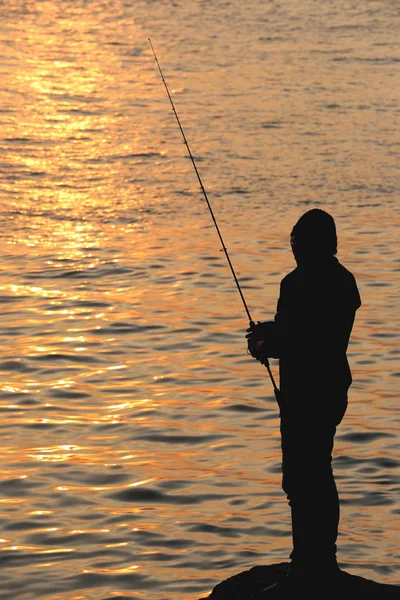 Fisherman of silhouette style on seaside. — Stock Photo, Image
