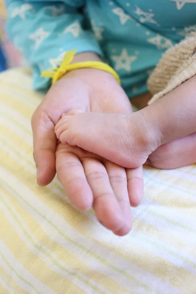 Babyfüße in der Hand der Mutter. — Stockfoto