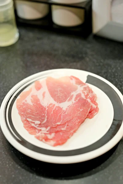 Krájené čerstvé vepřové maso na talíři. — Stock fotografie