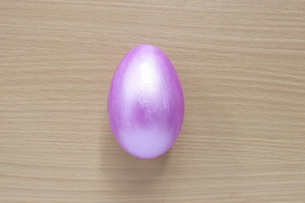 Фиолетовые пасхальные яйца на деревянном фоне . — стоковое фото