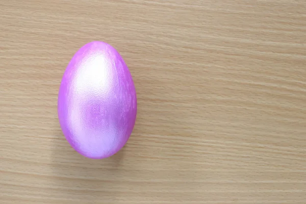 Фиолетовые пасхальные яйца на деревянном фоне . — стоковое фото