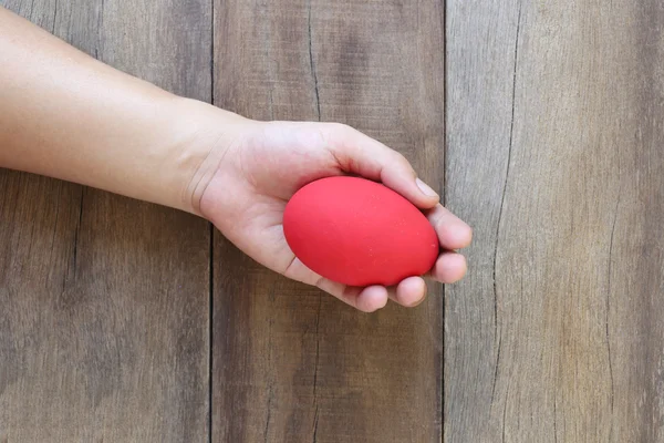 Easter eggs in hand on wood background. — Stock Photo, Image