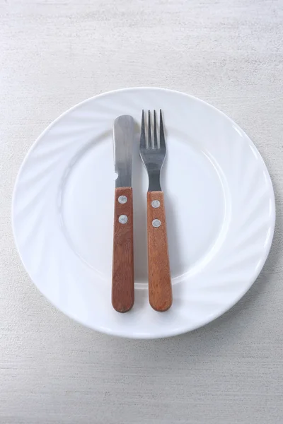 Bílé nádobí s vidličkou a nožem. — Stock fotografie