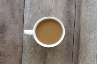 Eski ahşap zemin yerleştirilmiş beyaz kahve fincanı.