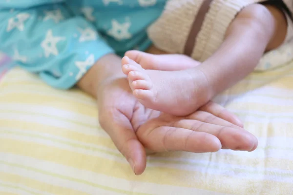 Baby feet in mom hand. — Stock Photo, Image