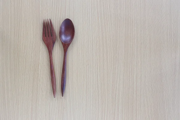 Houten lepel en vork in bovenaanzicht op houten achtergrond. — Stockfoto