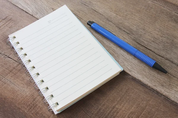 Caderno em branco e cor caneta no chão de madeira . — Fotografia de Stock