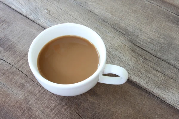 Copo de café branco em um piso de madeira . — Fotografia de Stock