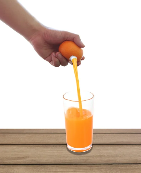 Fresh orange in hand and have fruit juice flowing into a glass o — Stock Photo, Image