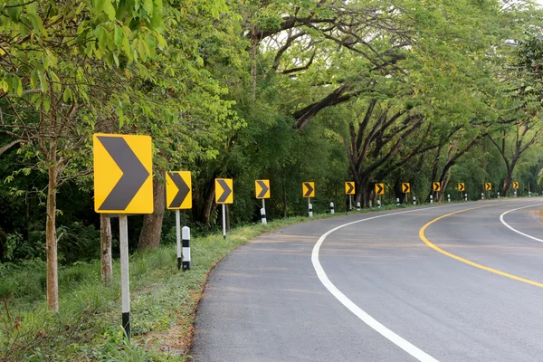 La curva de la carretera con señales de calle reflejo de luz . — Foto de Stock