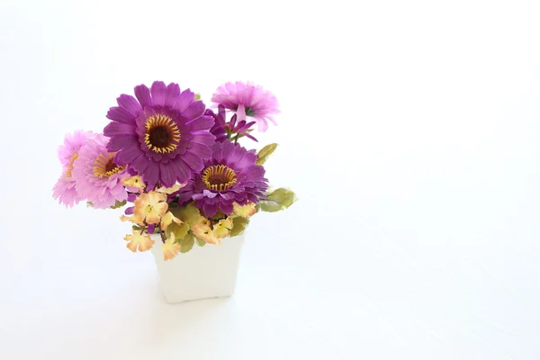 Flores artificiais rosa e violeta vintage em um tecido branco em — Fotografia de Stock