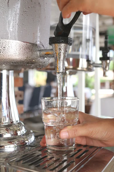 Vrouw handen waren het indrukken van koel water in drankje glas. — Stockfoto