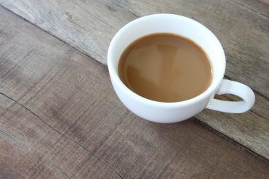 Bir ahşap zemin üzerinde beyaz kahve fincanı.