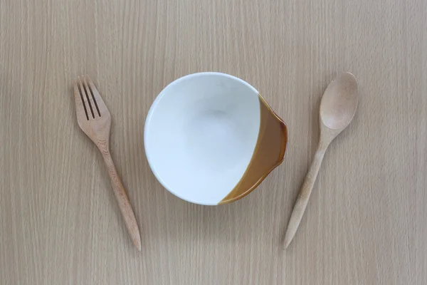 Cuchara de madera, tenedor y plato en vista superior sobre fondo de madera . —  Fotos de Stock