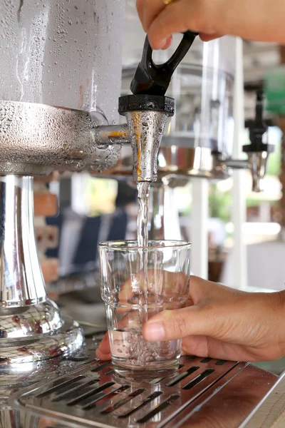 Frauenhände drückten kaltes Wasser in Trinkglas. — Stockfoto