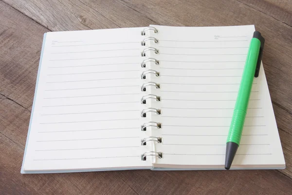 Lege notebook en pen kleur op houten vloer. — Stockfoto