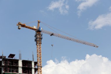 Bir bina yapım aşamasında gündüz çalışan vinç.