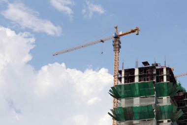 Bir bina yapım aşamasında gündüz çalışan vinç.