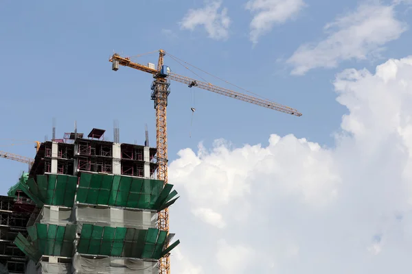 Crane werken op een gebouw in aanbouw in de dagtijd. — Stockfoto