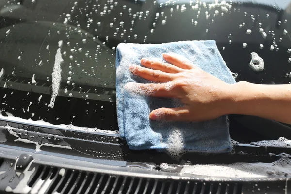 Femmes main dans laver une voiture avec du tissu en microfibre . — Photo