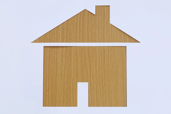 Paper shaped house on a background of brown wood. — Stock Photo, Image