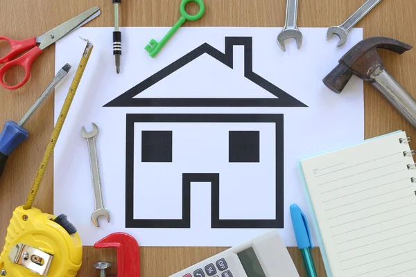 Paper shaped house on a background of brown wood and Craftsman t — Stock Photo, Image