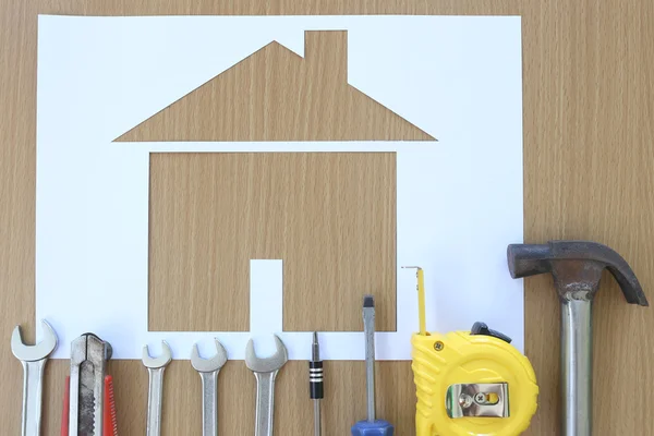 Paper shaped house on a background of brown wood and Craftsman t