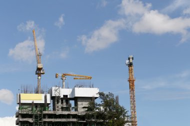 Bir bina yapım aşamasında gündüz çalışan vinç.