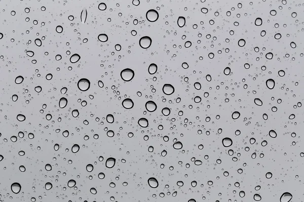 Gota de água para o fundo na janela do carro de vidro para abstrair — Fotografia de Stock